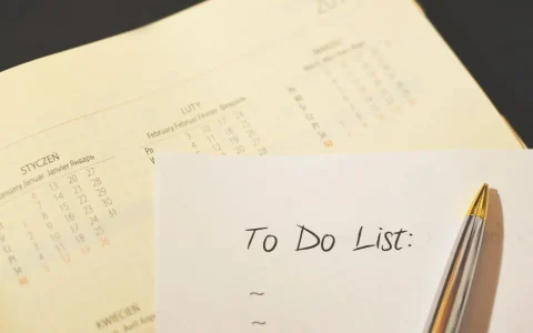 Kartka z napisem „To Do List” i długopis na tle kalendarza
